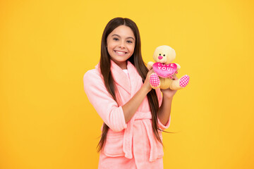 happy teen girl in home terry bathrobe with toy, joy