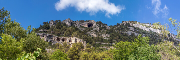 Fototapeta na wymiar Mountain cliffs with caves in Fontaine-de-Vaucluse, Provence, France