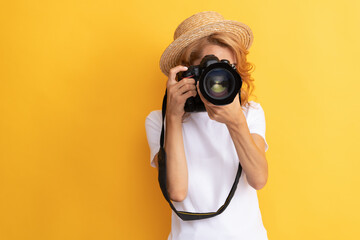 woman travel photographer with camera in straw hat making photo, focus