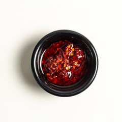 Plato de salsa picante de chile rojo y aceite en vista superior