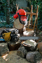 Kettensäge mit Schutzhandschuhen und Sicherheitshelm