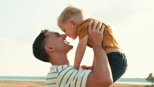 Close-up view of a happy father with his son rubbing noses in nature