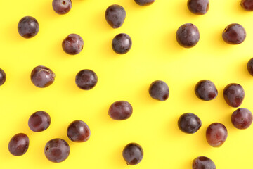 Red grapes isolated top view in yellow background