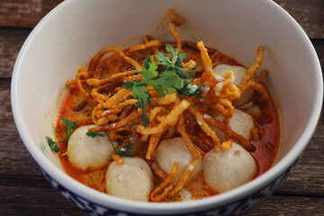 Local northern Thai food Egg noodle curry with meatballs on wood background