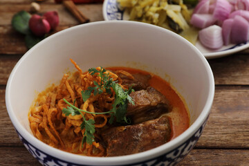 Local northern Thai food Egg noodle curry with pork ribs on wood background