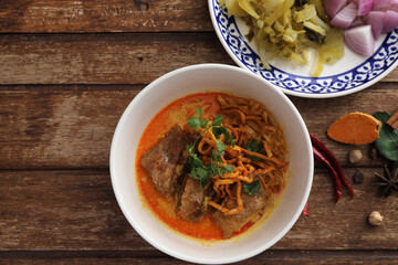 Local northern Thai food Egg noodle curry with pork ribs on wood background