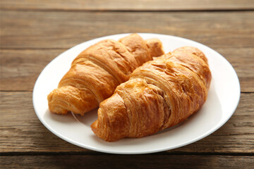 Freshly croissant on plate on grey wooden background