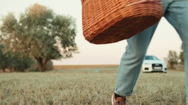 Smiling father and son running with a picnic basket in their hands