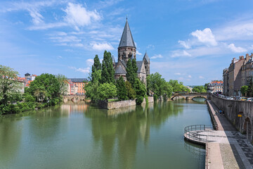 Fototapeta na wymiar Temple Neuf (New Temple), a Protestant city church in Metz, France. View from a bridge across the Moselle river.