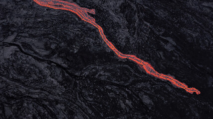 hot lava running on solidified black lava