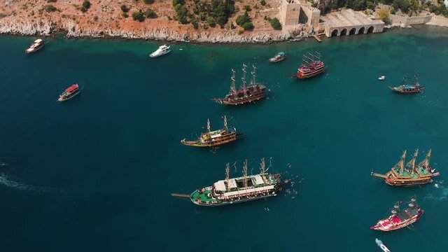 Aerial top down view of ships and boats in the mediterraneanresort. Alanya bay in Turkey, Summer day. Travel and vacation. Entertaining tourists and swimming in the sea.