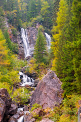 Beautiful Pissandolo waterfall in beautiful autumn colors in the Dolomites, in the province of...