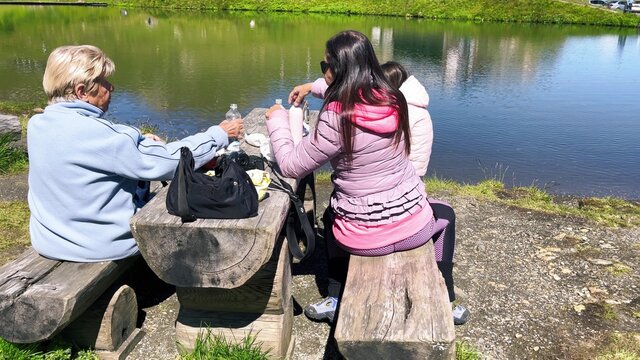 Happy family having a picknic at wonderful alpin lake.