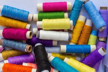multicolour sewing thread bobbin on white background
