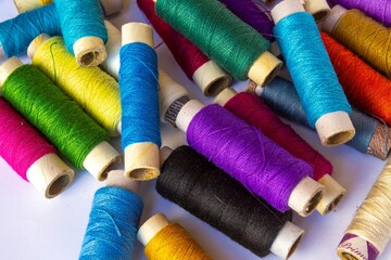 multicolour sewing thread bobbin on white background