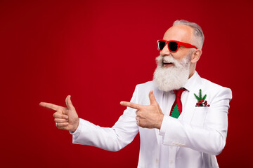 Fototapeta na wymiar Photo of funny old white hair man look point empty space wear eyewear white jacket isolated on red color background