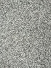 The texture of a slightly wet asphalt of a large fraction under a fine drizzle