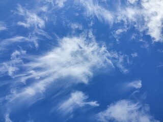 Cirrus clouds rush, driven by the wind, smearing across the sky
