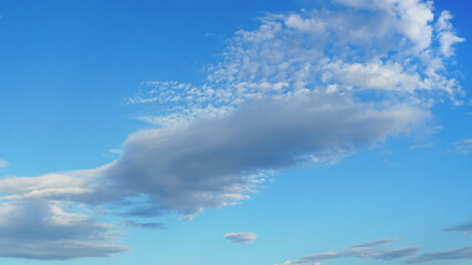 Large cloud angling against blue sky suitable for background or sky substitution
