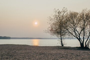 Fototapeta na wymiar Сloudy sunset on the lake shore. Lake landscape. Autumn