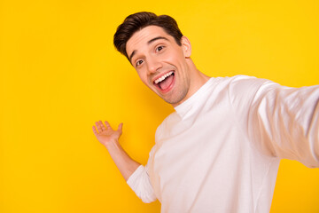 Photo of cool brunet millennial guy do selfie wear shirt isolated on yellow background