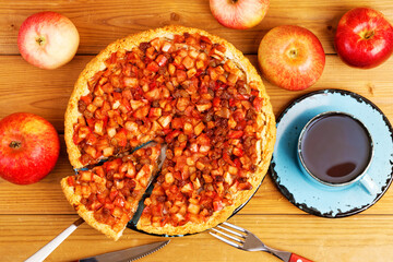 Homemade pie with apples, raisins and cinnamon on wooden table. Top view.