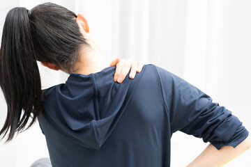 肩こりに悩む女性の後ろ姿