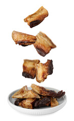 Tasty fried pork lard falling into plate on white background