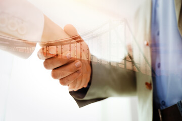 Double exposure of bridge and business partners shaking hands indoors, closeup