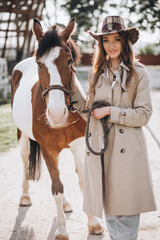 Fototapeta premium Young happy woman with horse at ranch