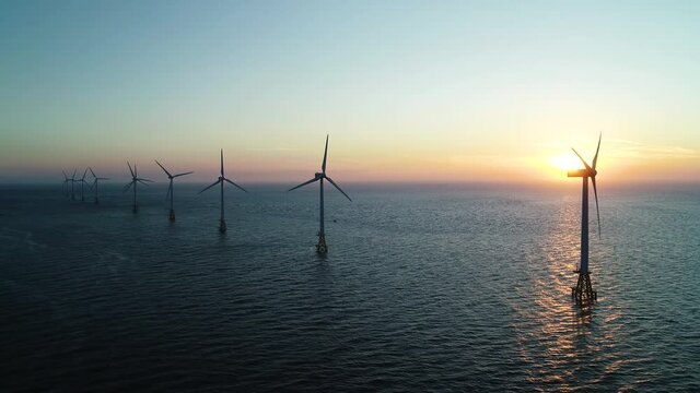 Beautiful sunset background the wind power generators on the sea, Offshore wind turbine in Jeju Island. South Korea. 제주 해안 풍력발전