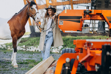 Young happy woman with horse at ranch