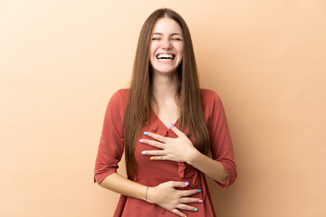 Obraz premium Young caucasian woman isolated on beige background smiling a lot
