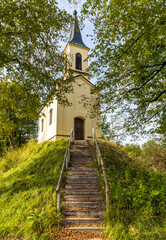 Kiensee chapel with wooden stairs surrounded by trees, Bad Heilbrunn, Bavaria, Germany
