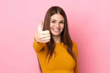 Young caucasian woman isolated on pink background with thumbs up because something good has happened