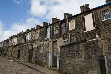 A steep terrace of traditional 19th century millworkers' cottages, seen from the back lane between Basil Street and Walton Street: Colne, Lancashire, UK