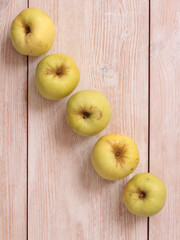 Big green apple on a kitchen scale on a wooden table