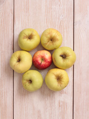 Big green apple on a kitchen scale on a wooden table
