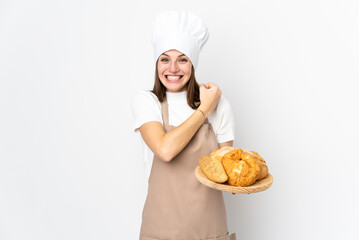 Young woman in chef uniform isolated on white background celebrating a victory