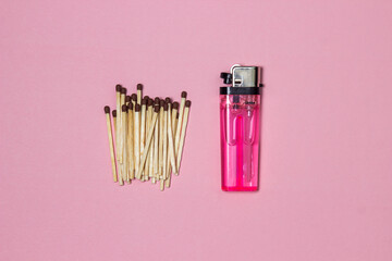 Matches and a lighter on a pink background. Pink plastic lighter