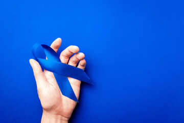 Cancer men. Awareness prostate cancer of men health in November. Blue ribbon in hands isolated on...