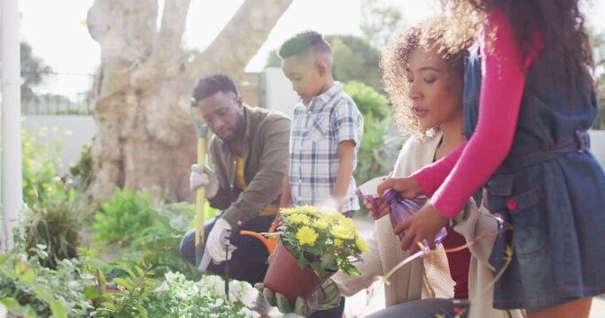 Happy african american parents with children gardening together