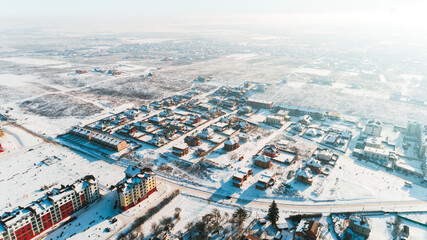 Top view of the winter village with snow covered houses and roads. Aerial view of landscape