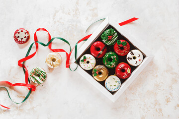 Colorful doughnuts in a gift box and beside. Christmas  Doughnuts with sugar icing  as a gift. Top...