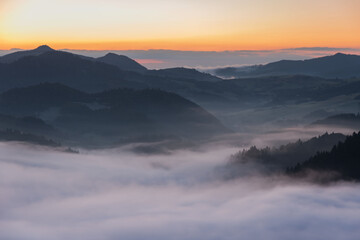 Golden autumn in the mountains with morning mists and yellow-red leaves on the trees