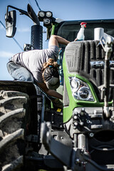 Woman cleaning tractor on a sunny summer day