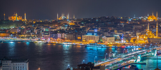 Naklejka premium ISTANBUL - SEPTEMBER 17, 2014: City night panorama with Blue Mosque and Hagia Sophia on background. Istanbul is visited by more than 11 million people every year