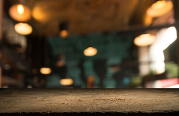 Naklejka na ściany i meble Empty dark wooden table in front of abstract blurred bokeh background of restaurant . can be used for display or montage your products.Mock up for space