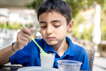 Little boy eating ice cream at cafe