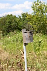 The old wood box birdhouse in the field.